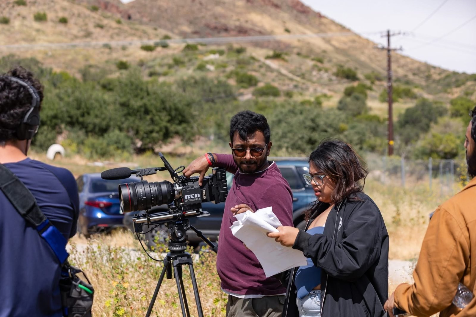 Ajijul Hasan Surzo directing on location beside a RED camera with crew and cast